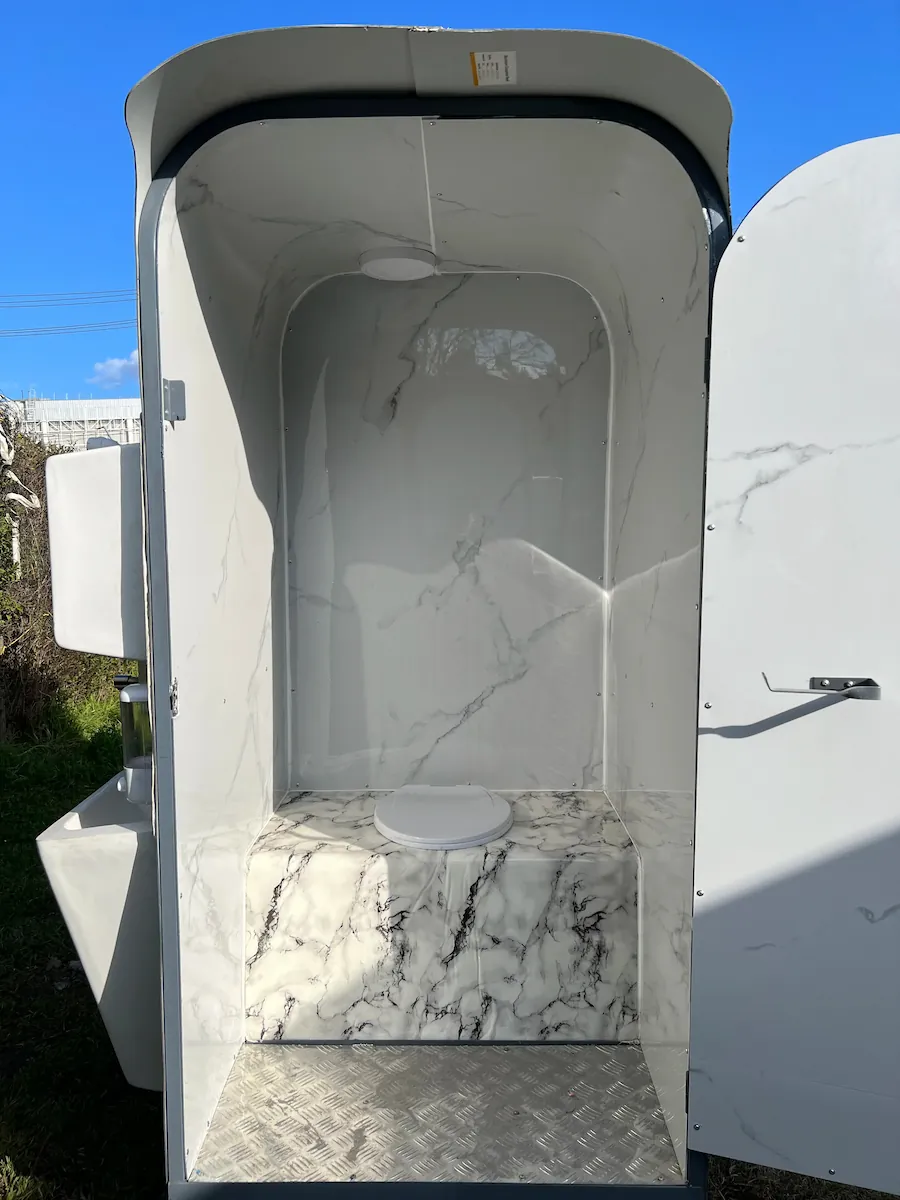 Vista interior trasera del baño químico doble de arrastre